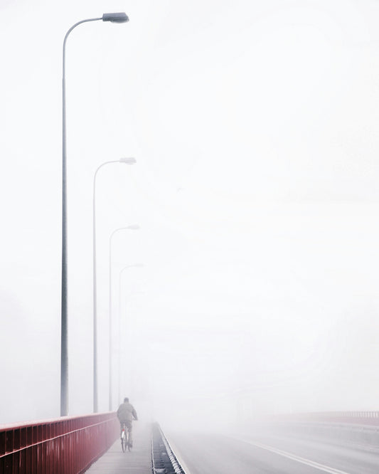 Cyclist on a Foggy Bridge