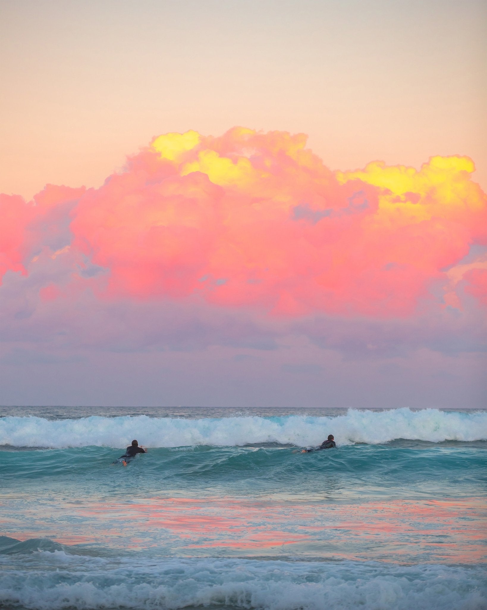 Surfers Ride The Waves At Sunset
