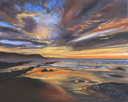 Serene Sunset Over A Rocky Beach