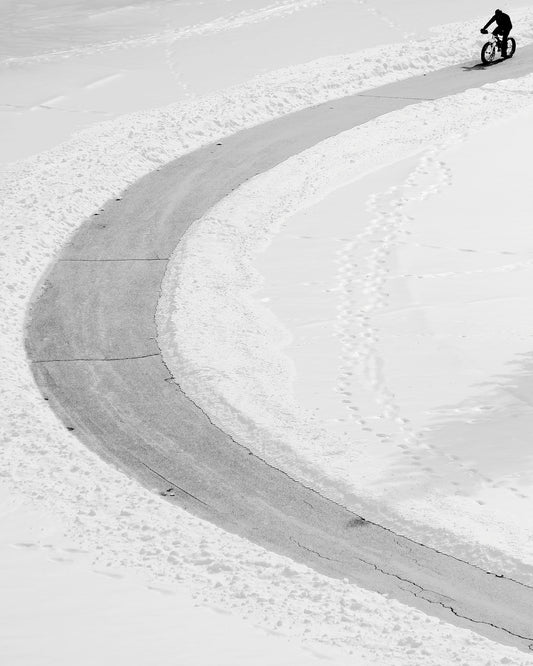 Lone Cyclist in Snow
